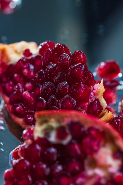 在一个反射表面上的整个和切片石榴的极端特写-库存照片图片下载