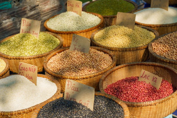 在河内街头的露天市场上，一袋袋不同种类的豆类，纸板上写着坚果的名字。图片下载