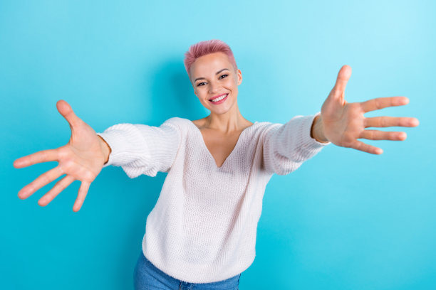 开朗乐观满意的女孩照片穿白色针织长袖想拥抱你欢迎友好孤立在海蓝宝石的背景上图片下载