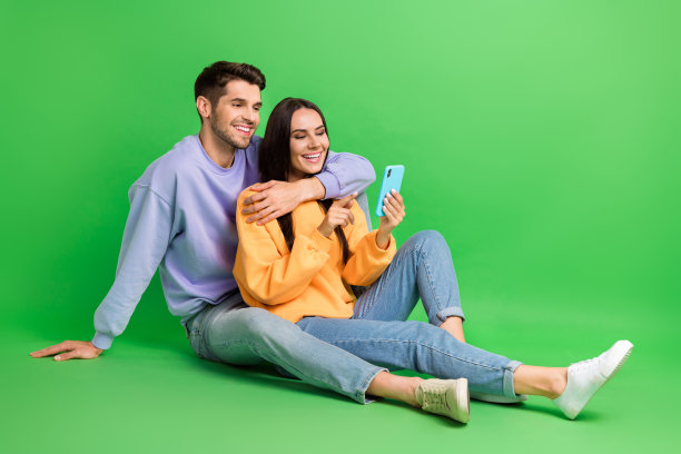 可爱的正面丈夫妻子的全身照片穿着交流现代设备孤立的绿色背景图片下载