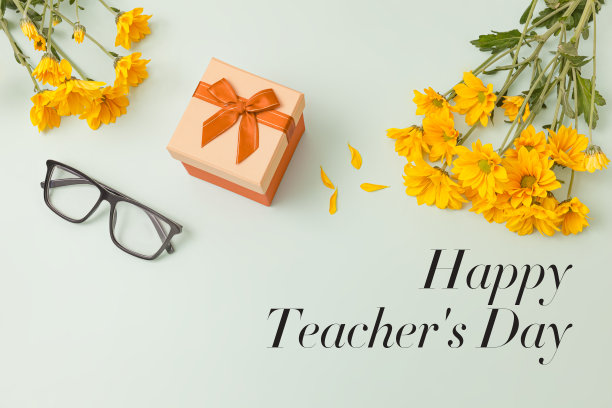 一束黄色的雏菊花，一个礼盒，淡绿色背景上的时尚黑色眼镜，上面有文字教师节快乐图片下载