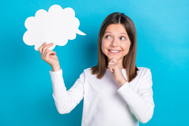 照片上积极梦幻的小女孩穿着白色衬衫手臂下巴看着心灵泡泡空空间孤立的蓝色背景图片下载