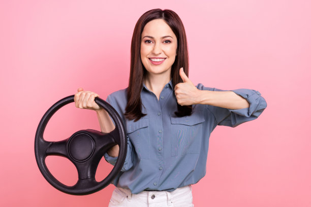 照片中迷人迷人的女士穿着时尚的衣服，展示了丰满的身材，享受着粉红色背景下的优质汽车图片下载