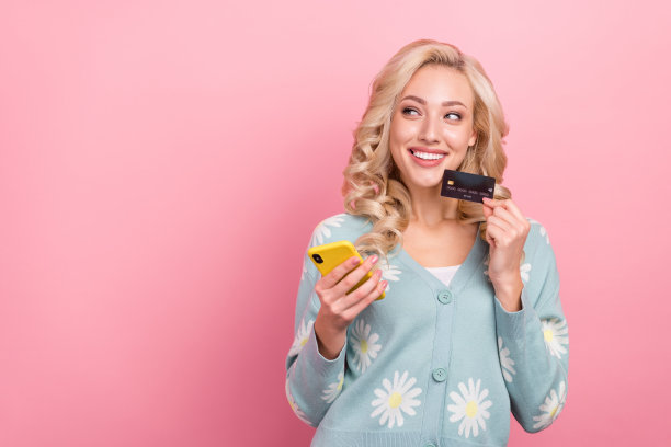 年轻的购物狂女孩的照片得到了薪水网上商店衣服拿电话浏览目录看模型孤立的粉红色背景图片下载