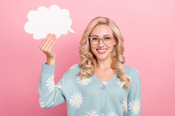 年轻卷发女子的照片穿绿松石衬衫雏菊印花持有纸泡沫讲话的想法孤立在粉红色的背景图片下载