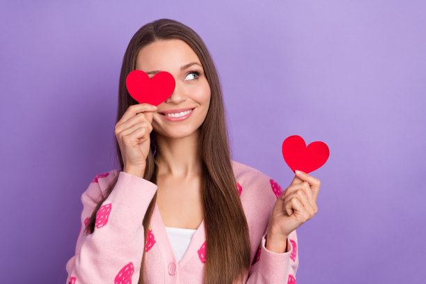 照片中有趣体贴的女孩穿着浆果印花开衫，看起来空空荡荡的心，闭上眼睛孤立的紫罗兰色背景图片下载