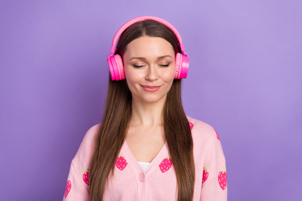 照片正面甜美的女孩戴浆果印花开衫耳机听歌曲孤立的紫罗兰色背景图片下载