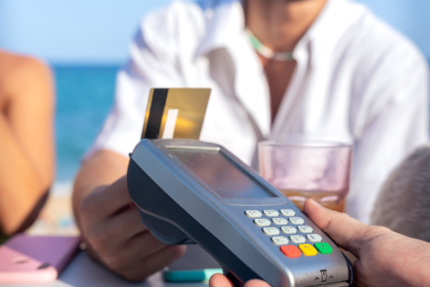 一名身份不明的男子在餐厅用非接触式信用卡付款。图片下载