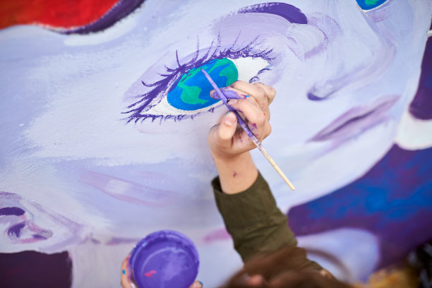 女画家用画笔在帆布上作画，准备参加户外街头展览图片下载