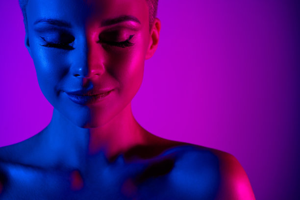迷人的时尚模特女士广告化妆品假日化妆霓虹灯效果背景的特写照片图片下载