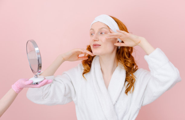 一个穿白袍的女人正在给一个女人做美容图片下载