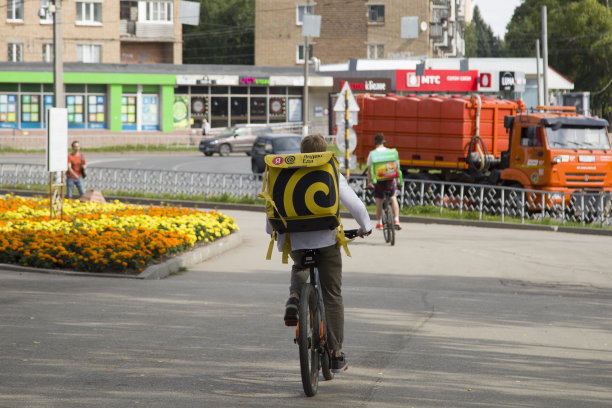 食品交付。快递员骑自行车递送货物的快递员图片下载
