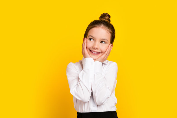 照片中可爱的女学生看起来空落落的，觉得穿校服孤立在黄色的背景上图片下载