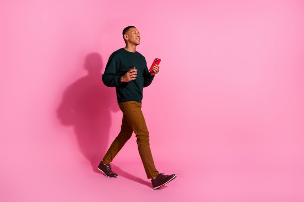 英俊的长照片好心情的家伙穿运动衫喝饮料文字现代小工具空旷的空间孤立的粉红色背景图片下载