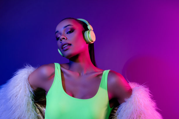 照片迷人梦幻的女士穿着皮草大衣听旋律耳机空的空间孤立的紫色背景图片下载