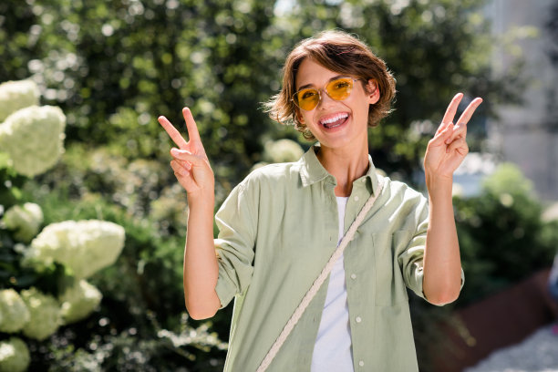 照片积极乐观闪亮的女孩高兴有乐趣好心情的手显示v标志绿色公园户外图片下载