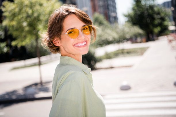 照片正面可爱闪亮的女孩穿着时尚的衣服享受阳光明媚的周末户外城市景观图片下载