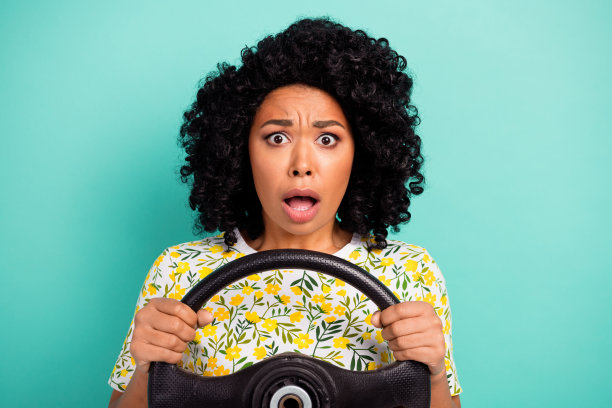 印象深刻的迷人的女士穿着印花t恤骑汽车空白空间孤立蓝绿色背景的照片图片下载