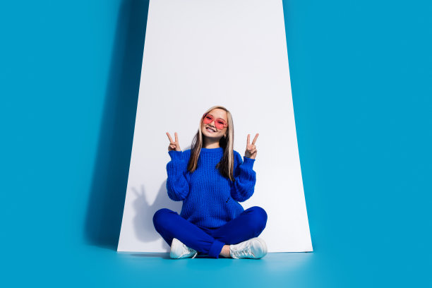 照片肖像时髦的韩国女孩在太阳镜广告手机显示触摸屏孤立的蓝色背景图片下载