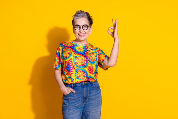 照片中漂亮的高级女性穿着时髦的印花衣服，标志被隔离在鲜艳的黄色背景上图片下载