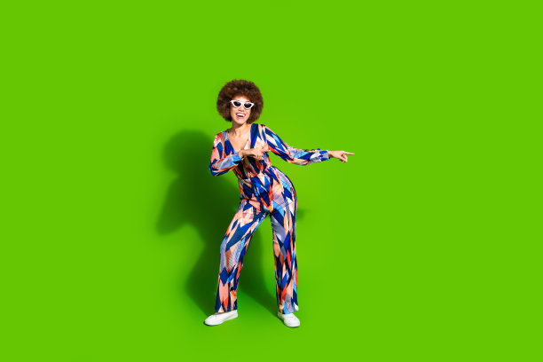 华丽的快乐的女人穿着时尚的衣服的全身照片显示空白的空间孤立在充满活力的绿色背景图片下载