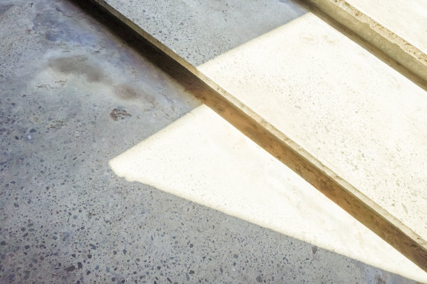 灰色水泥台阶的特写照片，阴影和阳光的对比曝光。混凝土楼梯。抽象的背景。图片下载