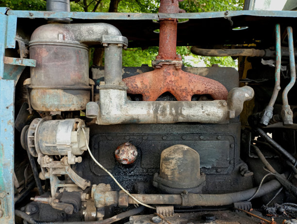 一台旧的拖拉机柴油发动机，发动机舱内有旧机油溢出的痕迹。旧柴油农机发动机背景。图片下载