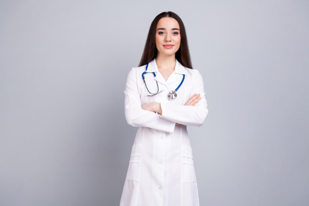 专业医务工作者的照片，女士交叉双臂，白色外套孤立在灰色背景上图片下载