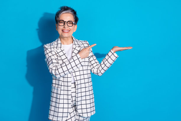 照片中积极开朗的女人穿着白色时尚的衣服，推荐在蓝色背景上隔离空的空间图片下载