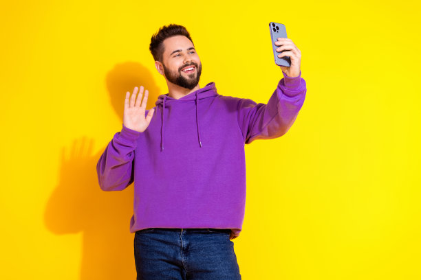 照片中，有魅力又好又有趣的男博主穿着时尚的衣服，在黄色背景下自拍hello图片下载