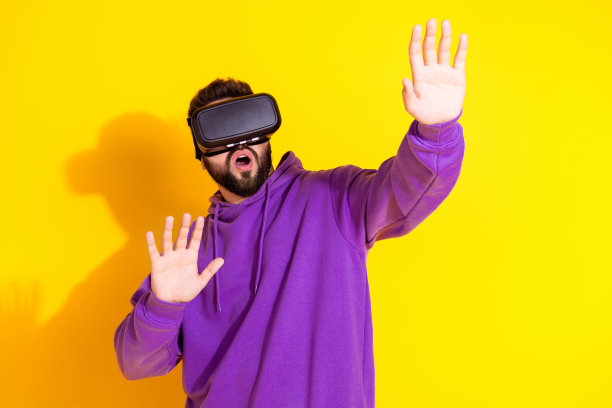 照片时髦迷人的男人穿着紫色时尚的衣服玩游戏空空间孤立在黄色的背景图片下载