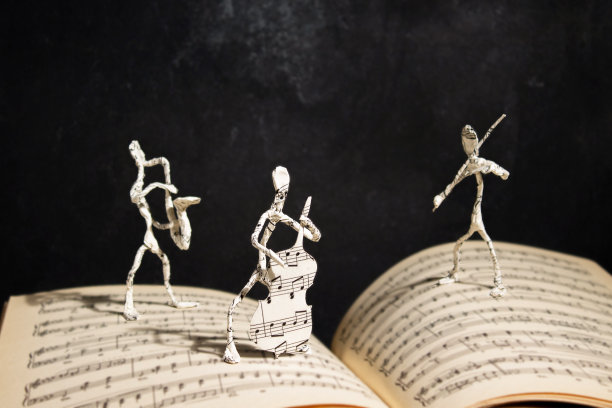 打开的音乐笔记本上立着爵士音乐家的纸质人像图片下载