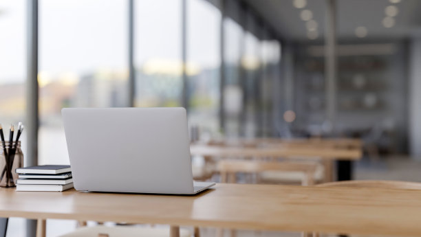 在咖啡厅或图书馆的阅读区，在木桌上放一台笔记本电脑。图片下载
