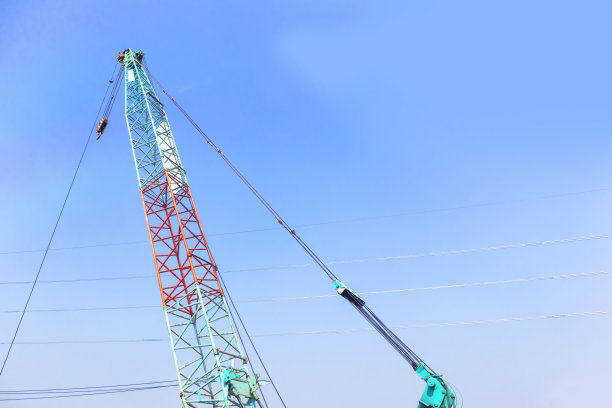 大型建筑起重机在高层建筑工程中施工。图片下载