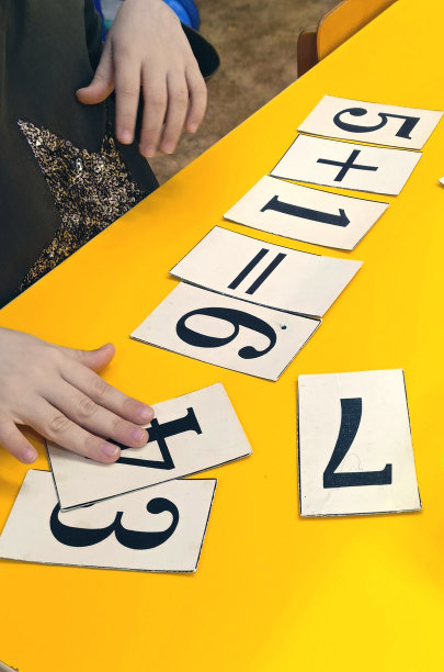 孩子们的手在硬纸板上写数字的特写。数学课，垂直照片。图片下载