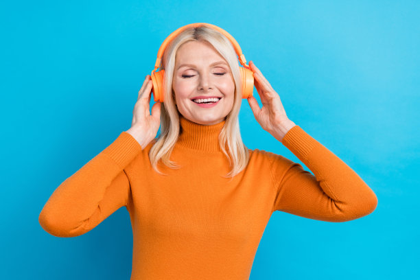 漂亮可爱的年长女士穿着时尚的衣服，享受最喜欢的轨道，感觉年轻孤立的蓝色背景的照片图片下载