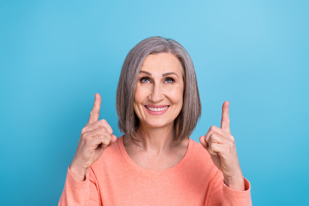 照片中迷人的高级商务女性穿着时髦的时髦休闲衬衫，看起来直接手指空白的空间新闻空白孤立在蓝色的背景图片下载