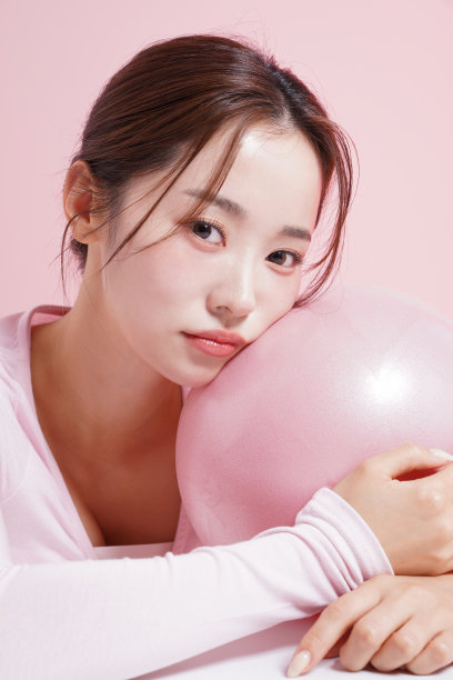 一个年轻女子在粉红色背景下拍摄的漂亮肖像图片下载