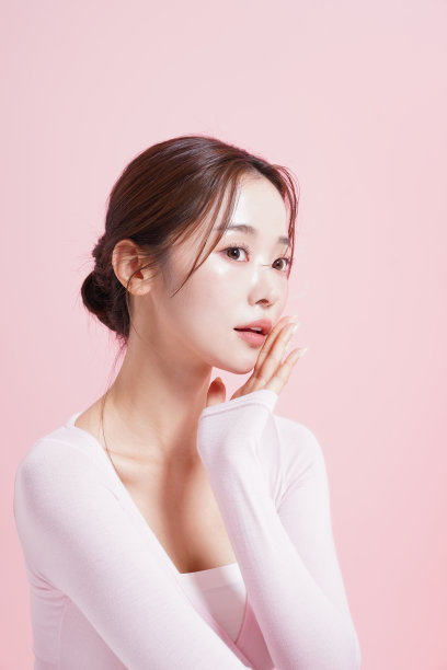 一个年轻女子在粉红色背景下拍摄的漂亮肖像图片下载