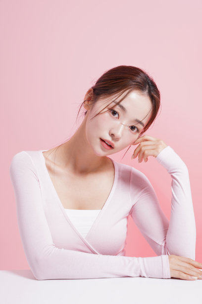 一个年轻女子在粉红色背景下拍摄的漂亮肖像图片下载