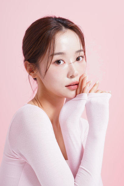 一个年轻女子在粉红色背景下拍摄的漂亮肖像图片下载