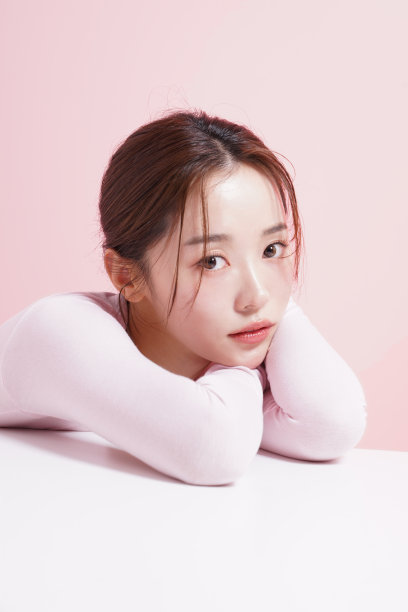 一个年轻女子在粉红色背景下拍摄的漂亮肖像图片下载