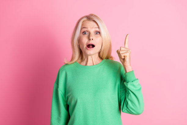 照片肖像可爱的高级女士手指指向尤里卡穿着时尚的绿色服装孤立在粉红色的背景图片下载