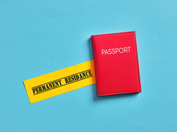 红色护照躺在蓝色背景的永久居留标志附近图片下载