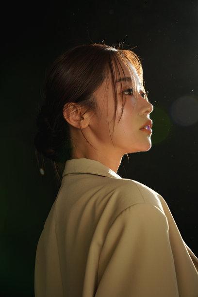 一个穿着夹克的年轻女子在夕阳下的忧郁肖像图片下载