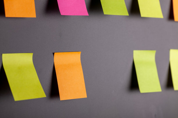 彩色便签贴在黑色的背景上图片下载
