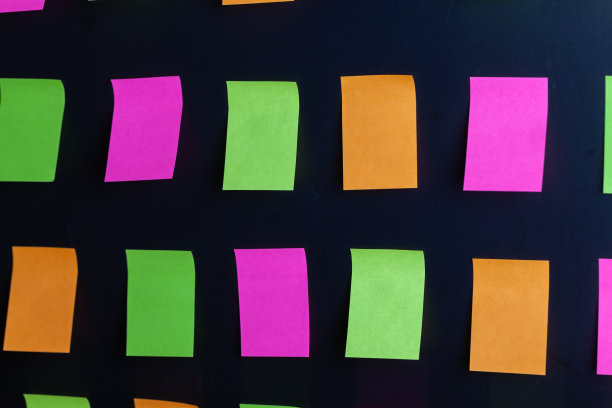 彩色便签贴在黑色的背景上图片下载