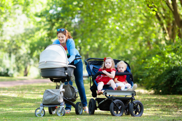 母亲带着三个孩子坐婴儿车和婴儿车图片下载