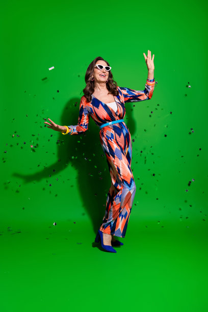 垂直全长照片迷人的积极的女人穿印花整体舞蹈空白空间孤立的绿色背景图片下载