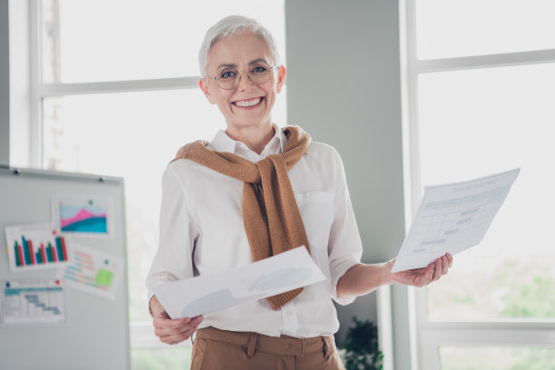 漂亮的老板成熟的女人照片拿图分析资料穿着正装舒适的光启动办公室阁楼房间内部图片下载